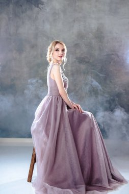 Zarif saç tarzı ile modern bir renk gelinlik gelin sarışın kadın ve makyaj. Dokulu arka plan üzerinde moda güzellik portre