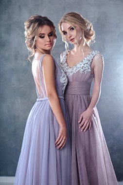 Modern renk Düğün Gelin sarışın genç kadınlarda zarif saç stili ile giysi ve makyaj. Moda güzellik portre kompozisyon dokulu arka plan üzerinde