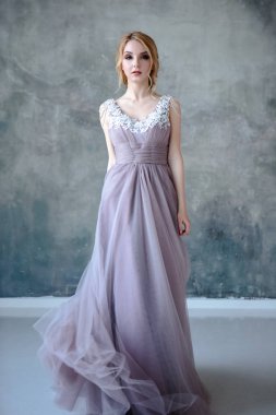 Zarif saç tarzı ile modern bir renk gelinlik gelin sarışın kadın ve makyaj. Dokulu arka plan üzerinde moda güzellik portre