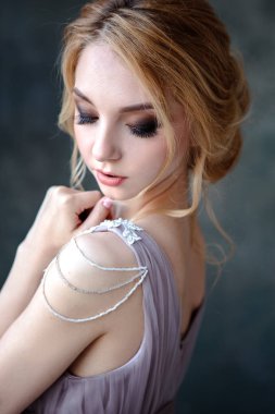 Zarif saç tarzı ile modern bir renk gelinlik gelin sarışın kadın ve makyaj. Dokulu arka plan üzerinde moda güzellik portre