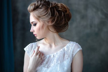 Zarif saç tarzı ile modern bir renk gelinlik gelin sarışın kadın ve makyaj. Dokulu arka plan üzerinde moda güzellik portre