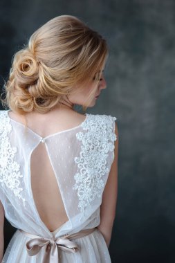 Zarif saç tarzı ile modern bir renk gelinlik gelin sarışın kadın ve makyaj. Dokulu arka plan üzerinde moda güzellik portre