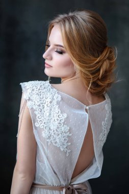 Zarif saç tarzı ile modern bir renk gelinlik gelin sarışın kadın ve makyaj. Dokulu arka plan üzerinde moda güzellik portre