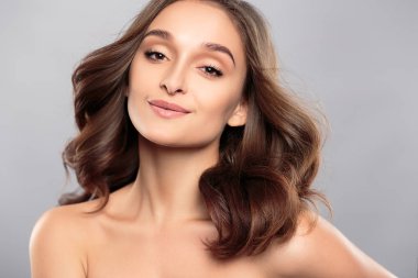 Esmer kız sağlıklı kıvırcık saçlı ve doğal makyaj. Güzel model kadınla dalgalı saç modeli. Bakım ve güzellik