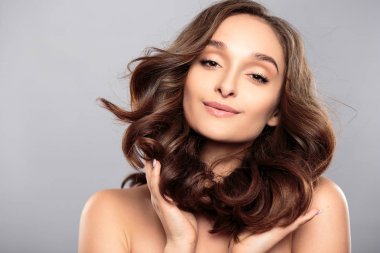 Esmer kız sağlıklı kıvırcık saçlı ve doğal makyaj. Güzel model kadınla dalgalı saç modeli. Bakım ve güzellik