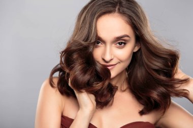 Esmer kız sağlıklı kıvırcık saçlı ve doğal makyaj. Güzel model kadınla dalgalı saç modeli. Bakım ve güzellik