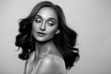 Esmer kız sağlıklı kıvırcık saçlı ve doğal makyaj. Güzel model kadınla dalgalı saç modeli. Bakım ve güzellik