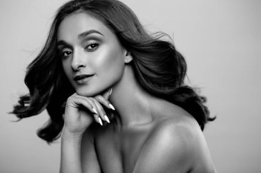 Esmer kız sağlıklı kıvırcık saçlı ve doğal makyaj. Güzel model kadınla dalgalı saç modeli. Bakım ve güzellik