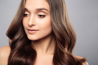 Esmer kız sağlıklı kıvırcık saçlı ve doğal makyaj. Güzel model kadınla dalgalı saç modeli. Bakım ve güzellik