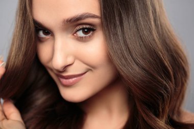 Esmer kız sağlıklı kıvırcık saçlı ve doğal makyaj. Güzel model kadınla dalgalı saç modeli. Bakım ve güzellik