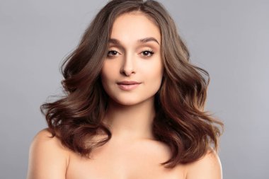 Esmer kız sağlıklı kıvırcık saçlı ve doğal makyaj. Güzel model kadınla dalgalı saç modeli. Bakım ve güzellik