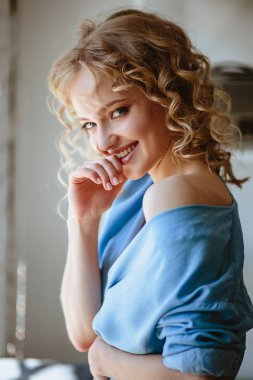 Kıvırcık saçlı ve doğal makyaj ile sarışın büyüleyici genç kadının portresi kadar kapatın. Güneşli sabah, spa ve bakım