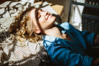 Genç sarışın kadın onu oturma odasında pencere yakınında ürpertici, güneşli hava, yaz saati