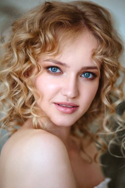 Kıvırcık saçlı ve doğal makyaj ile sarışın büyüleyici genç kadının portresi kadar kapatın. Güneşli sabah, spa ve bakım