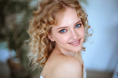 Kıvırcık saçlı ve doğal makyaj ile sarışın büyüleyici genç kadının portresi kadar kapatın. Güneşli sabah, spa ve bakım