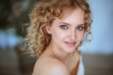 Kıvırcık saçlı ve doğal makyaj ile sarışın büyüleyici genç kadının portresi kadar kapatın. Güneşli sabah, spa ve bakım