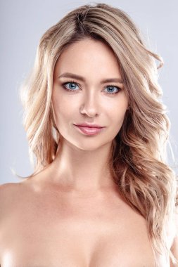 Sağlıklı kıvırcık saçlı ve doğal makyaj ile Sarışın genç kadın . Dalgalı saç modeli ile güzel model kız. Bakım ve güzellik