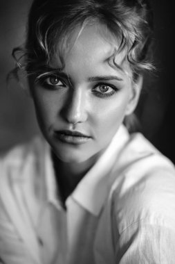 Bir çatı iç rahat beyaz gömlek ve kot genç sarışın kadın, moda portre kadar yakın