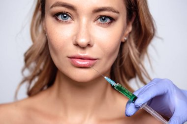 Yüzüne yakın kozmetolojist elleri ile sarışın kadının portresi kadar yakın. Salon, spa ve bakım da prosedür
