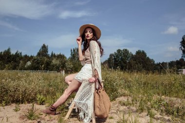 Şık bir yaz örgü giysiler açık poz güzel esmer genç kadın. Doğa üzerine moda güzellik portresi