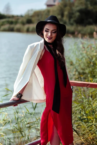 Retrato Brilhante Mulher Morena Vestido Vermelho Casaco Branco Posando Natureza — Fotografia de Stock