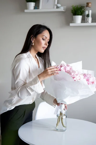 年轻女子手持淡淡的粉红绣花束 在家中的特写照片 — 图库照片