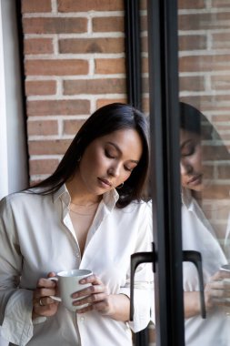 Genç bir kadın modern, parlak ve rahat bir dairede dinleniyor, İskandinav tarzı. Yaşam tarzı, özen ve rahatlama
