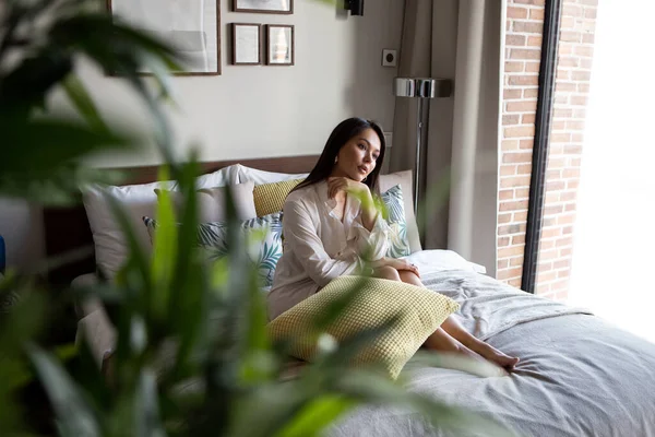 若い女性は 現代の明るく居心地の良いアパートメントで スカンディナヴィアスタイルの休息を持っています ライフスタイル リラクゼーション ロイヤリティフリーのストック画像