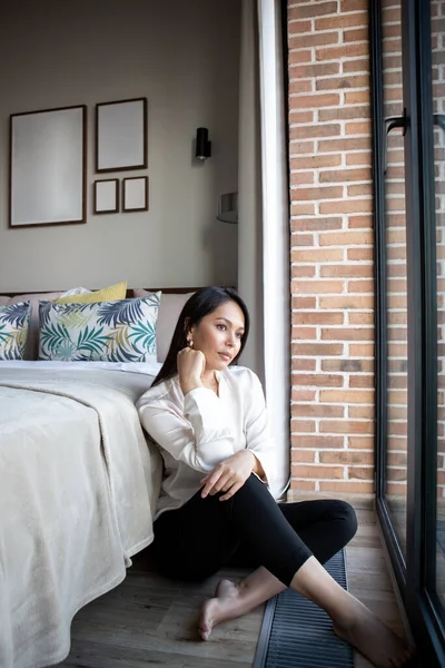 若い女性は 現代の明るく居心地の良いアパートメントで スカンディナヴィアスタイルの休息を持っています ライフスタイル リラクゼーション ロイヤリティフリーのストック写真