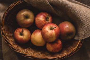 Hasır sepette taze toplanmış elmalar.