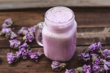 güler yüzlü kızılcık ve eski bir ahşap masa üzerinde kurutulmuş çiçek