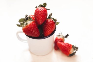 bir beyaz emaye kupa üç çilek