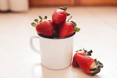 bir beyaz emaye kupa birkaç çilek