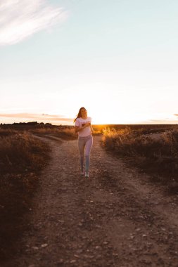 gün batımında alanında çalışan genç kadın