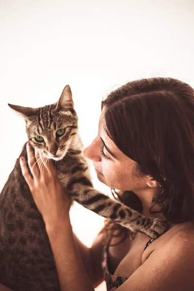 Bonita jovem mulher beijando seu gato tabby no verão — Fotografia de Stock