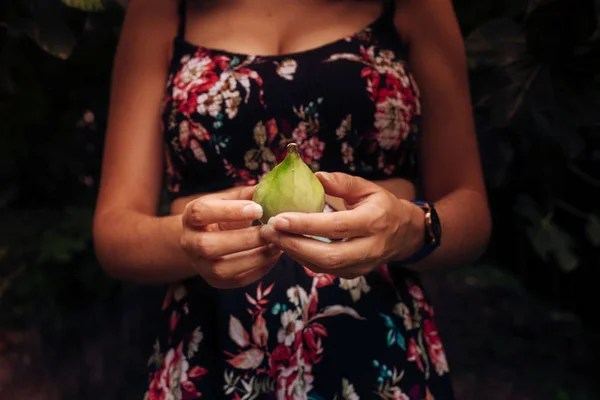 ผู้หญิงสาวที่มีชุดดอกไม้และมะเดื่อในมือของเธอ — ภาพถ่ายสต็อก
