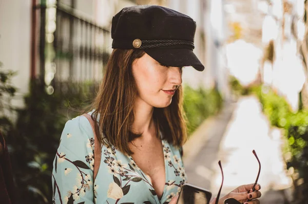 Mujer con gorra marinera quitándose las gafas de sol — Foto de Stock