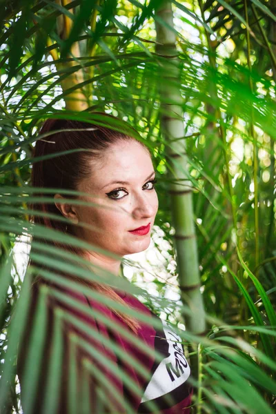 Bonita joven con mirada intensa entre palmeras — Foto de Stock