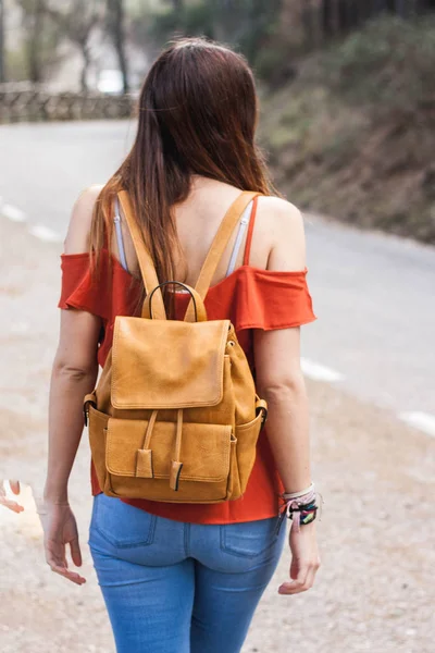 Mujer joven con mochila de cuero de color claro caminando en una caminata por la montaña — Foto de Stock