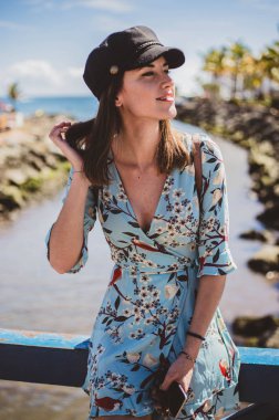 siyah bir kap ile saçlarına dokunarak tropikal bir yerde model