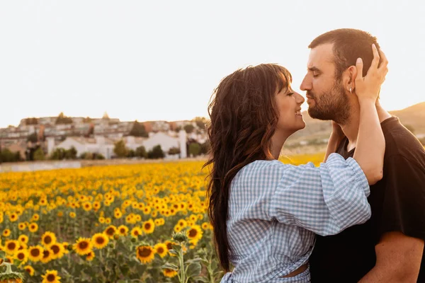 Jovem casal apaixonado no campo de girassol ao pôr do sol — Fotografia de Stock