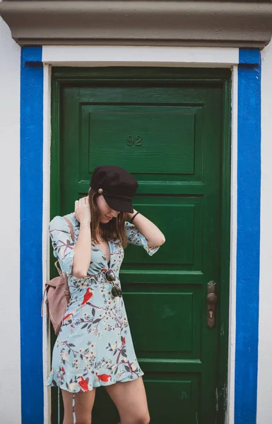 Bonita mujer joven en una puerta verde mirando al suelo — Foto de Stock