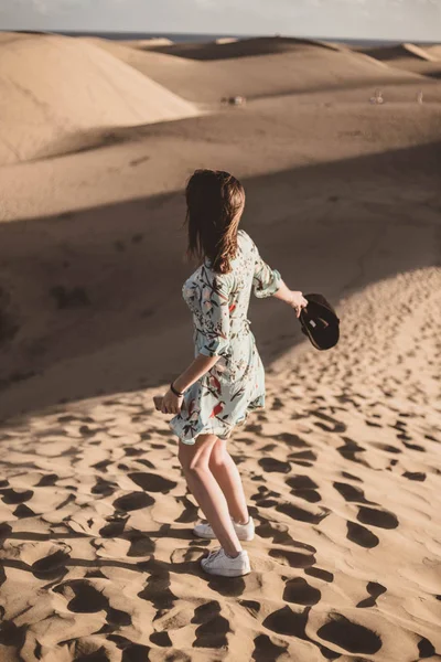 Donna nel deserto sulla schiena con un telefono cellulare in mano — Foto Stock