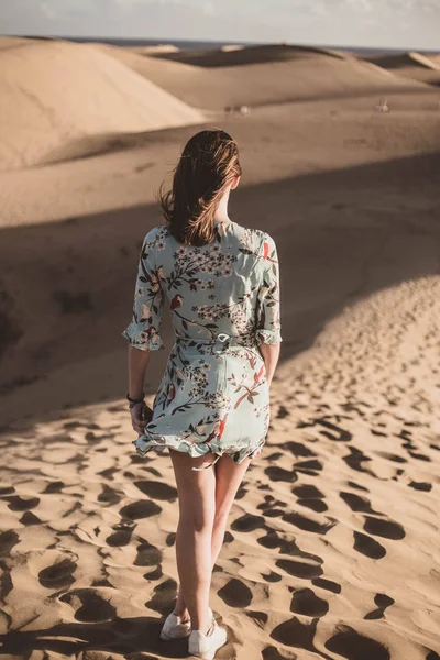 Donna nel deserto con bel vestito floreale guardando l'orizzonte — Foto Stock