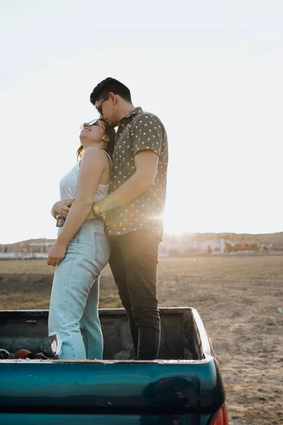 คู่สาวที่สวยงามจูบกันบนรถจี๊ป 4x4 ในตอนพระอาทิตย์ตก — ภาพถ่ายสต็อก