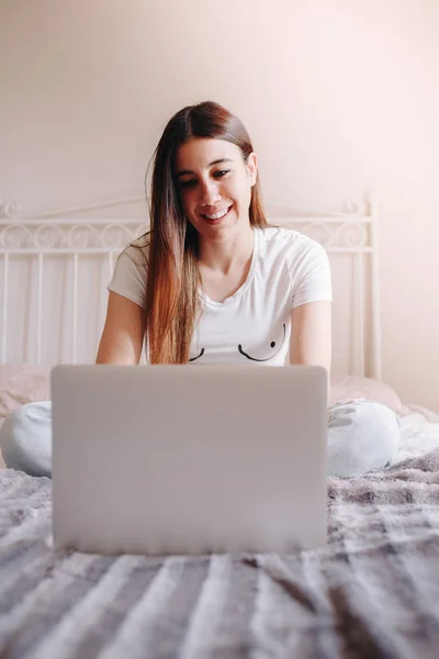 สาวสวยยิ้มและเขียนบนแล็ปท็อปของเธอ — ภาพถ่ายสต็อก