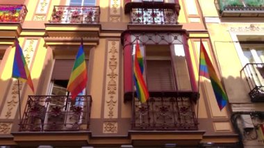 şehirde mavi gökyüzüne karşı gökkuşağı Lgbt bayrağı dalgalar