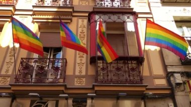 şehirde mavi gökyüzüne karşı gökkuşağı Lgbt bayrağı dalgalar
