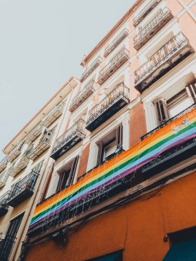 Madrid şehrinde mavi gökyüzüne karşı gökkuşağı LGBT bayrağı