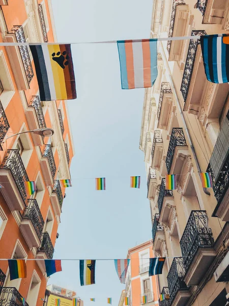 Arco iris bandera LGBT contra cielo azul en la ciudad de Madrid — Foto de Stock